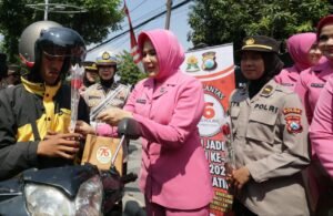 Sapa Warga di Hari Jadi ke -76, Polwan Polrestabes Surabaya Turun Jalan Berbagi Helm dan Bunga