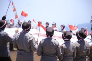 Hari Jadi ke-76, Polwan Polres Madiun Kibarkan Merah Putih dan Bendera Polwan di Puncak Bukit Mongkrang