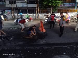 Polsek Krian Dampingi Relawan Tambal Sulam Jalan Raya Basuki Rahmat 
