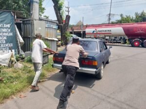 Polsek Krian Beri Pelayanan Humanis,Sigap Bantu Mendorong Mobil Mogok di Jalan Perempatan RPH Katerungan Krian