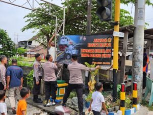 Polisi Pasang Spanduk Himbauan di Perlintasan Kereta Api Tidak Berpalang 